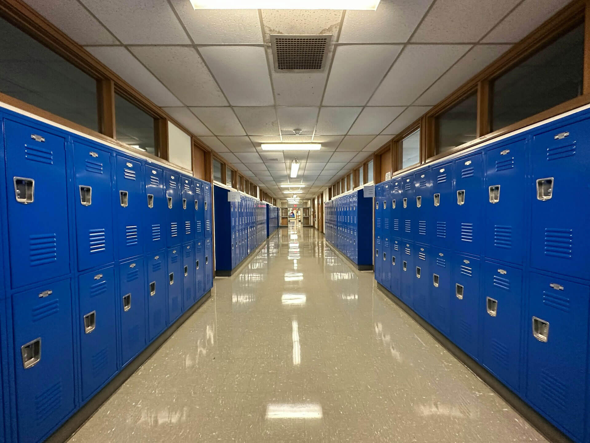 a school hallway with rows of blue lockers